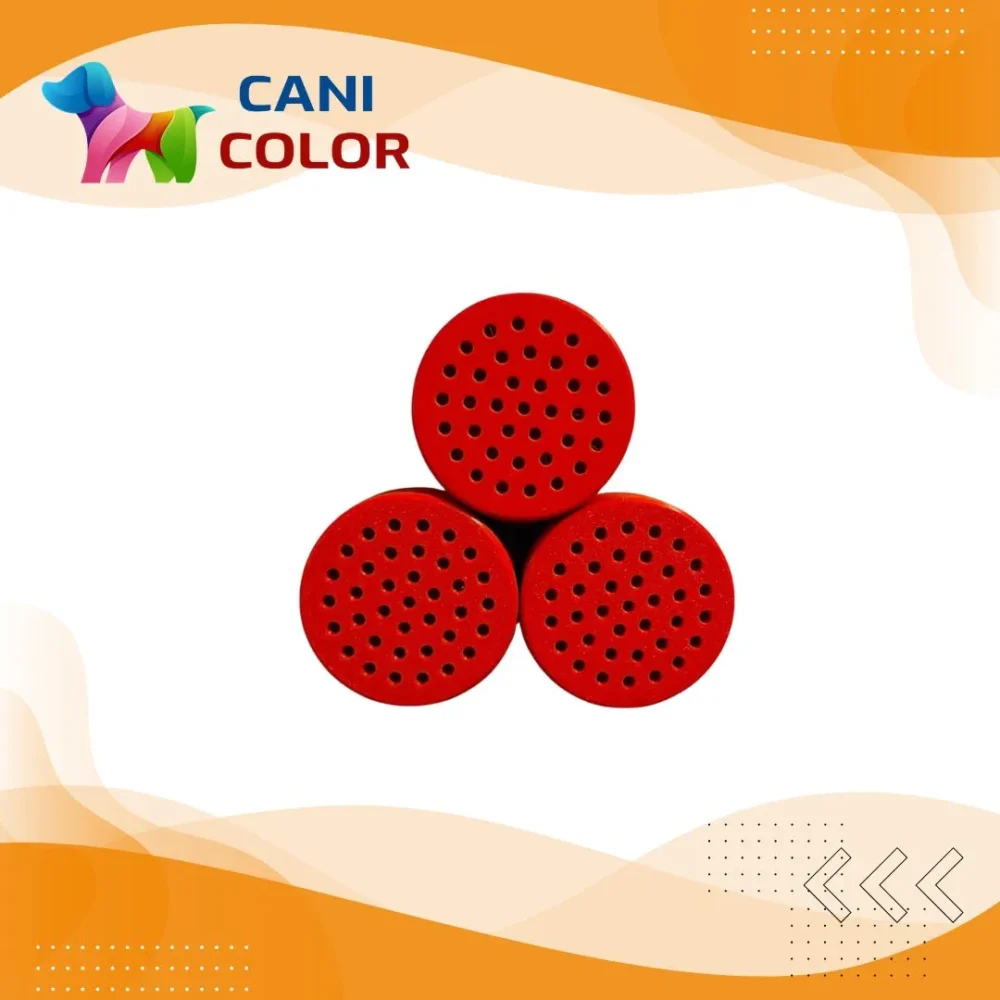 Three red, round objects with holes arranged in a triangular formation against a light background.